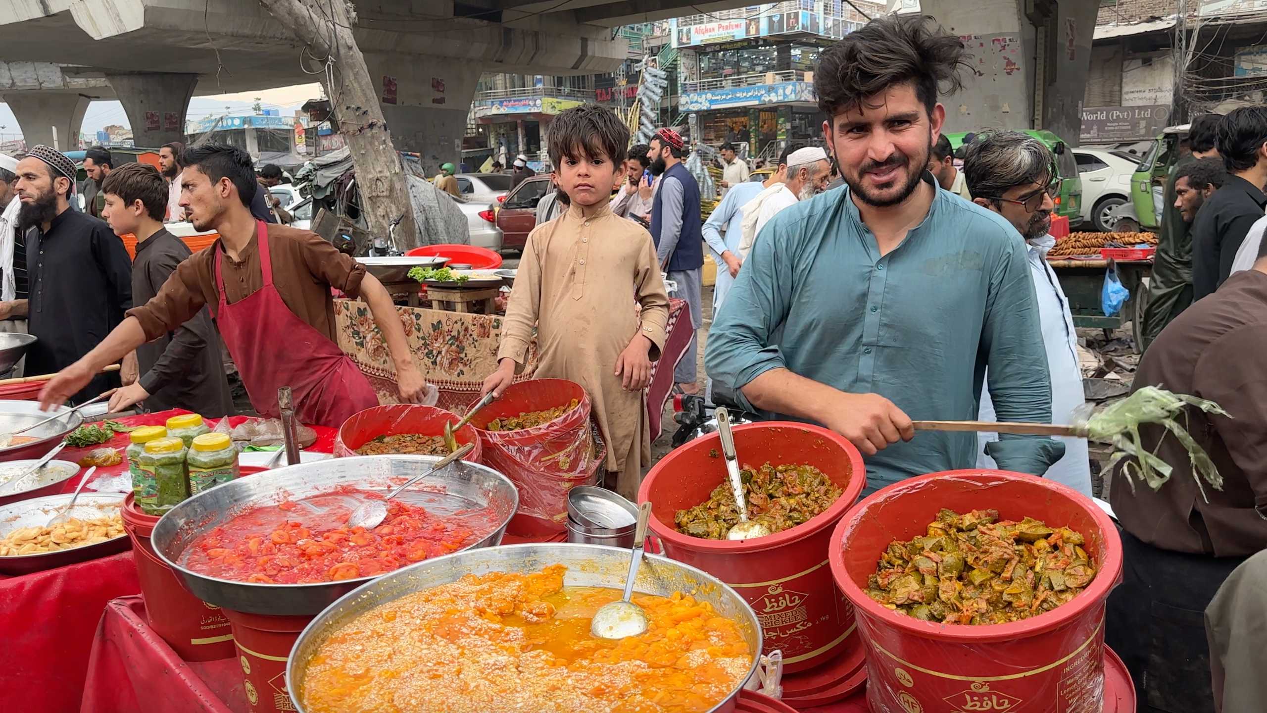 A vendor proudly displaying his large pots of colorful, flavorful dishes.