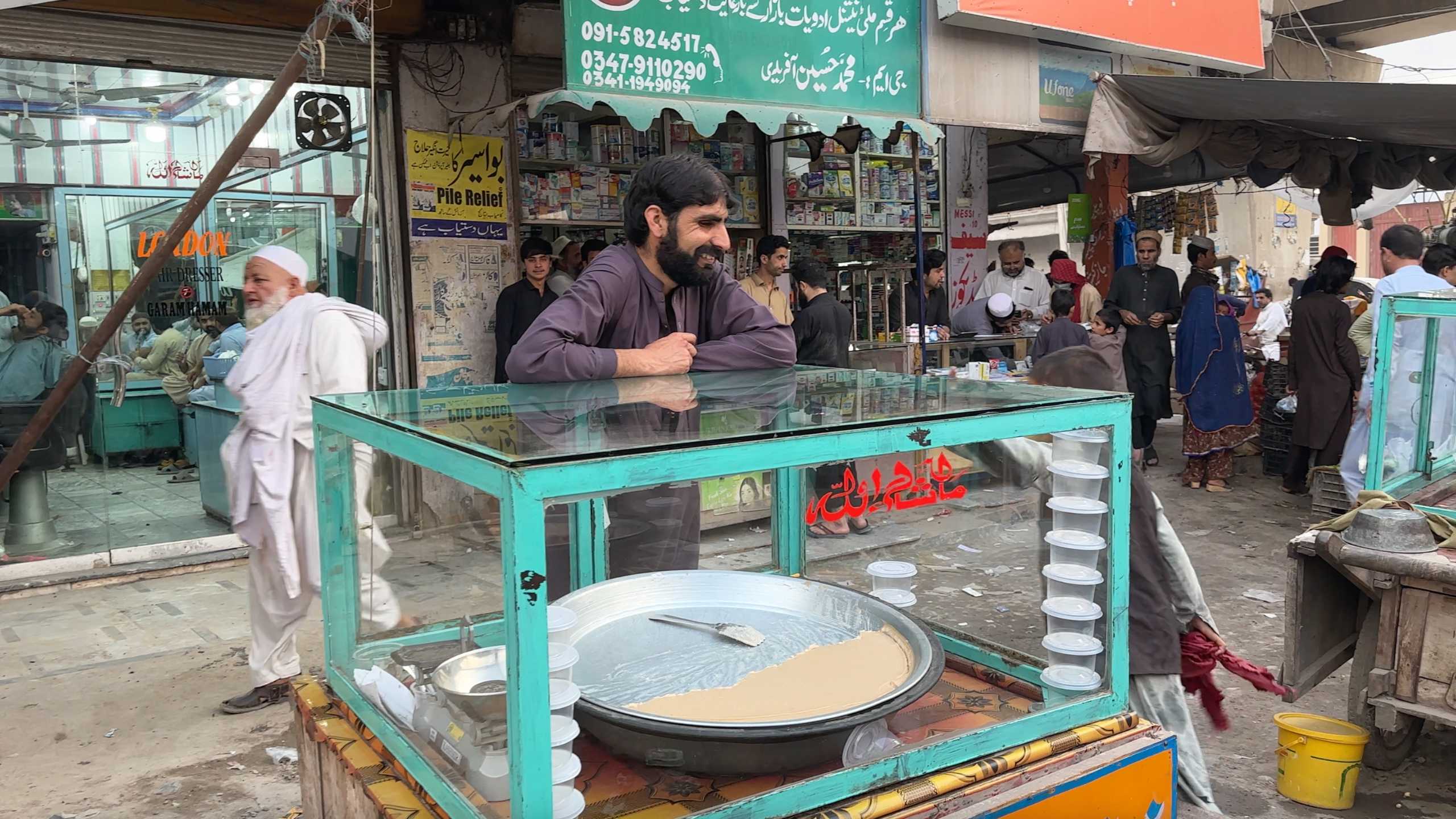 A local vendor standing by his dessert cart, ready to serve customers.