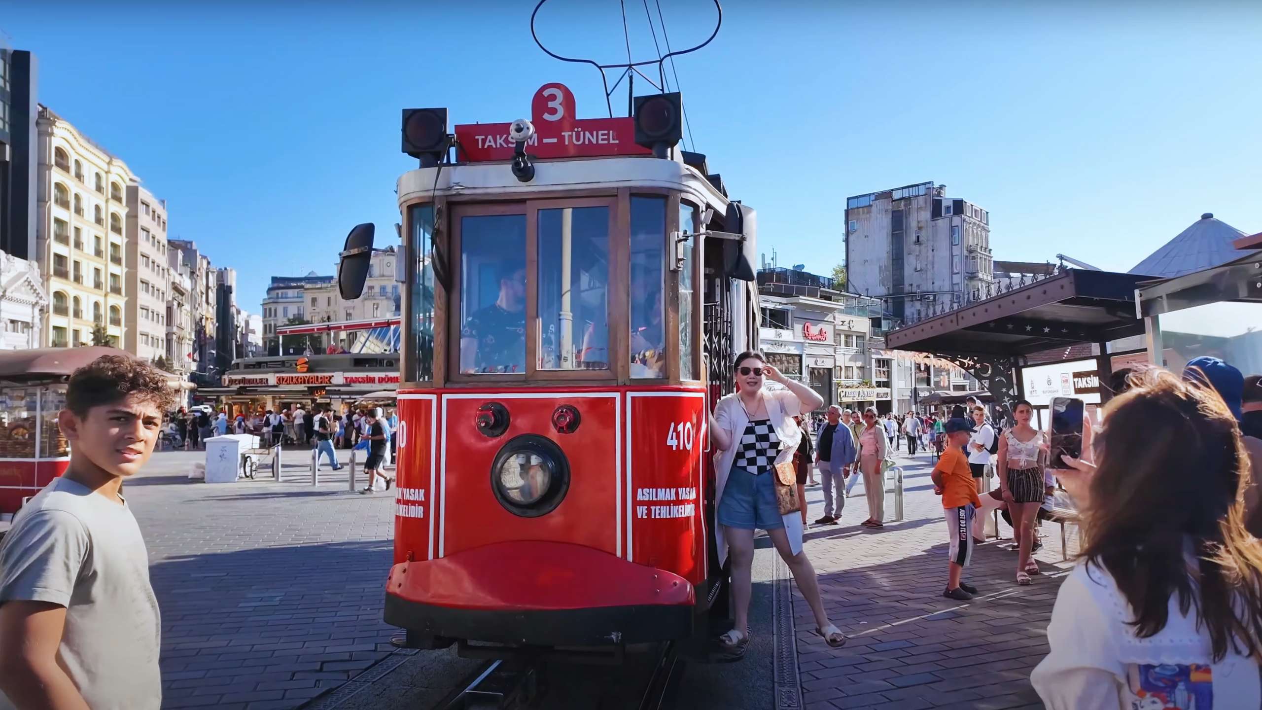 Tourists eagerly posing and taking photos with Istanbul’s historic red tram.