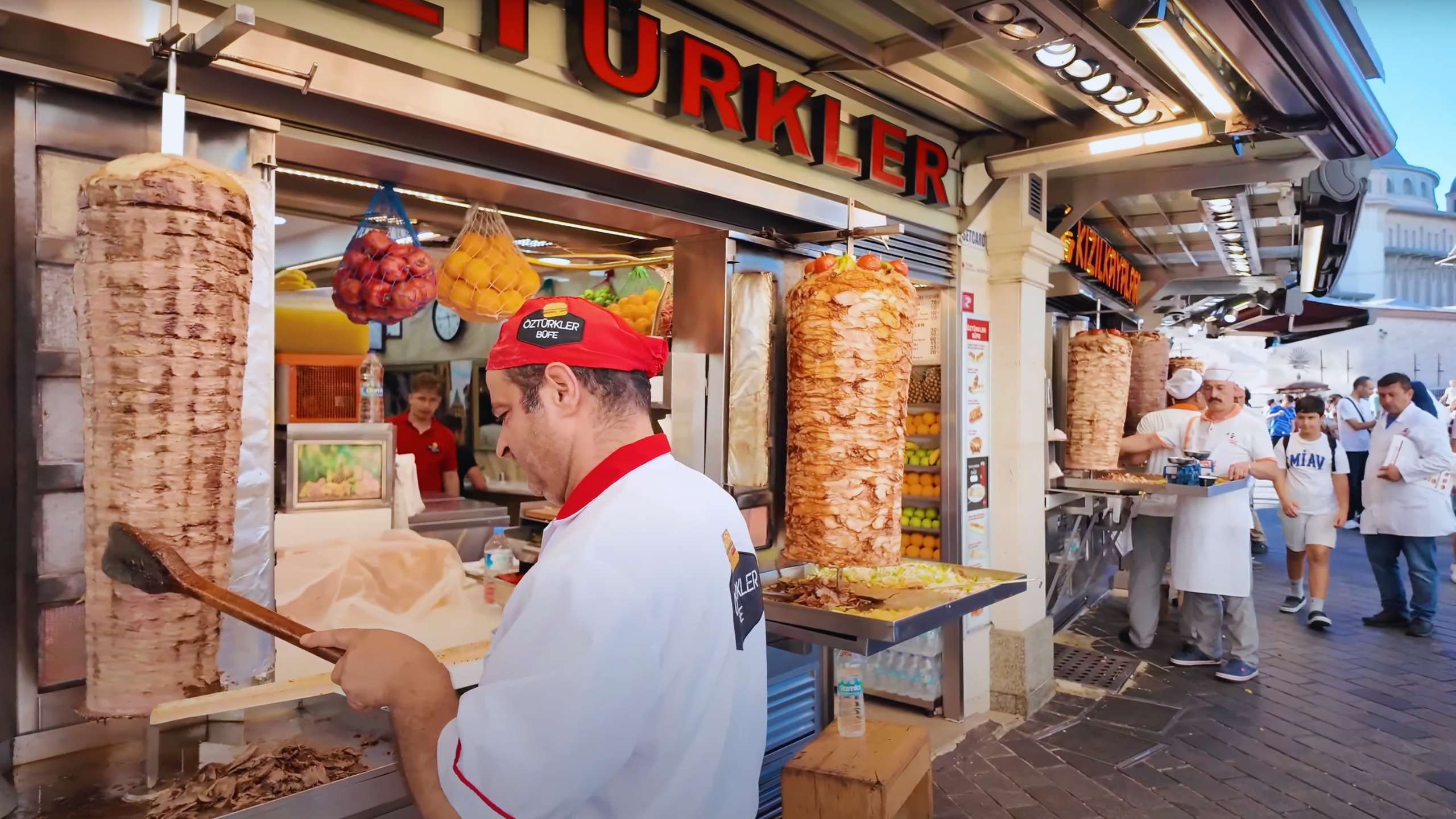 Street food vendors preparing juicy döner kebabs in a bustling Istanbul setting.