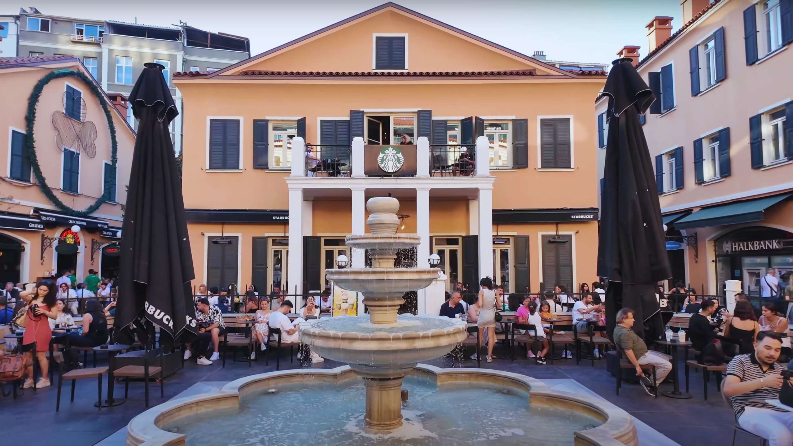 Fountain in front of a classic cafe setting, where visitors relax and enjoy the lively ambiance.