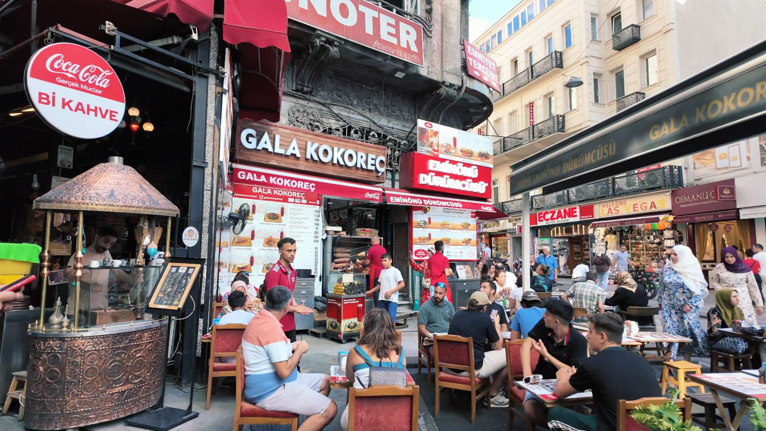 Diners enjoying local delicacies at an outdoor seating area of a kokoreç shop.