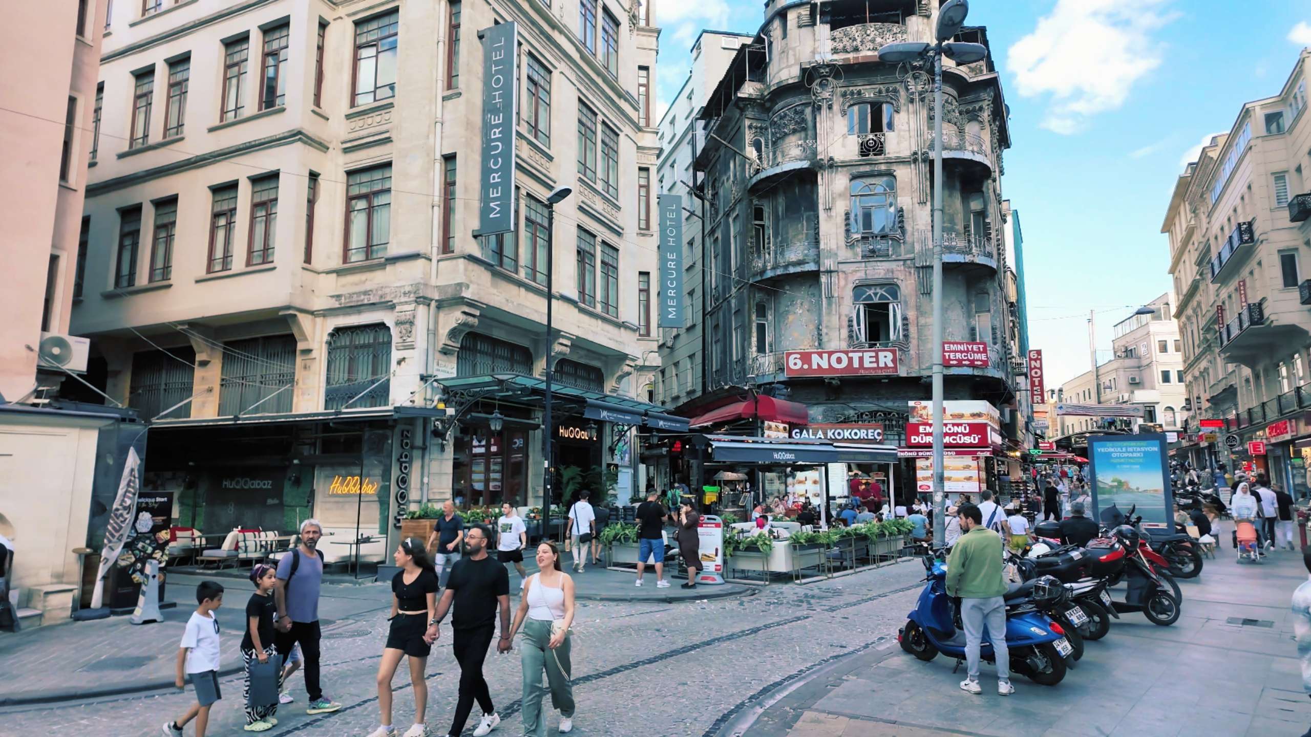 A lively street scene showcasing Istanbul's blend of historic architecture and bustling modern-day shops.