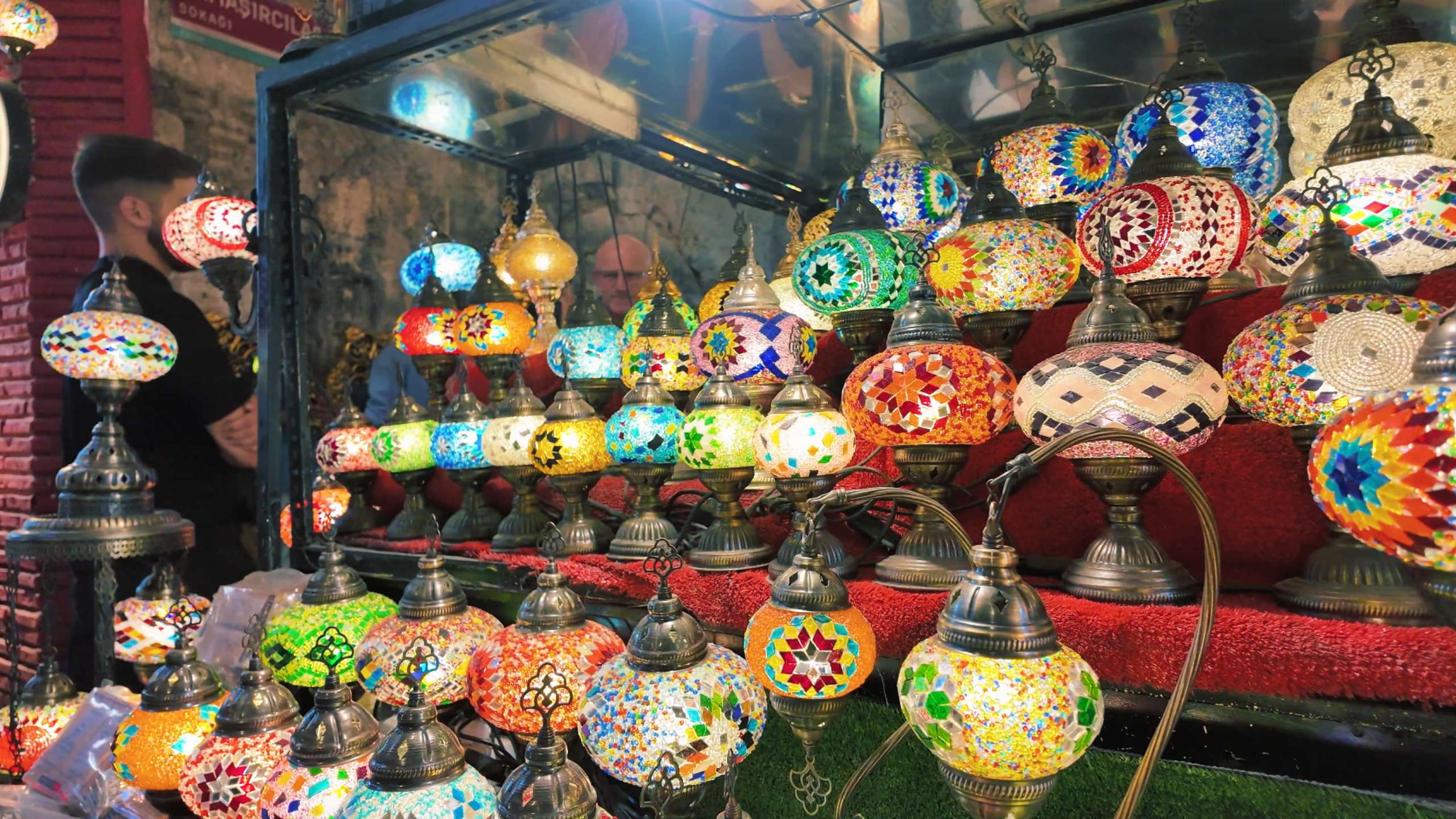 Brightly colored mosaic lamps illuminate the shop with a warm glow.