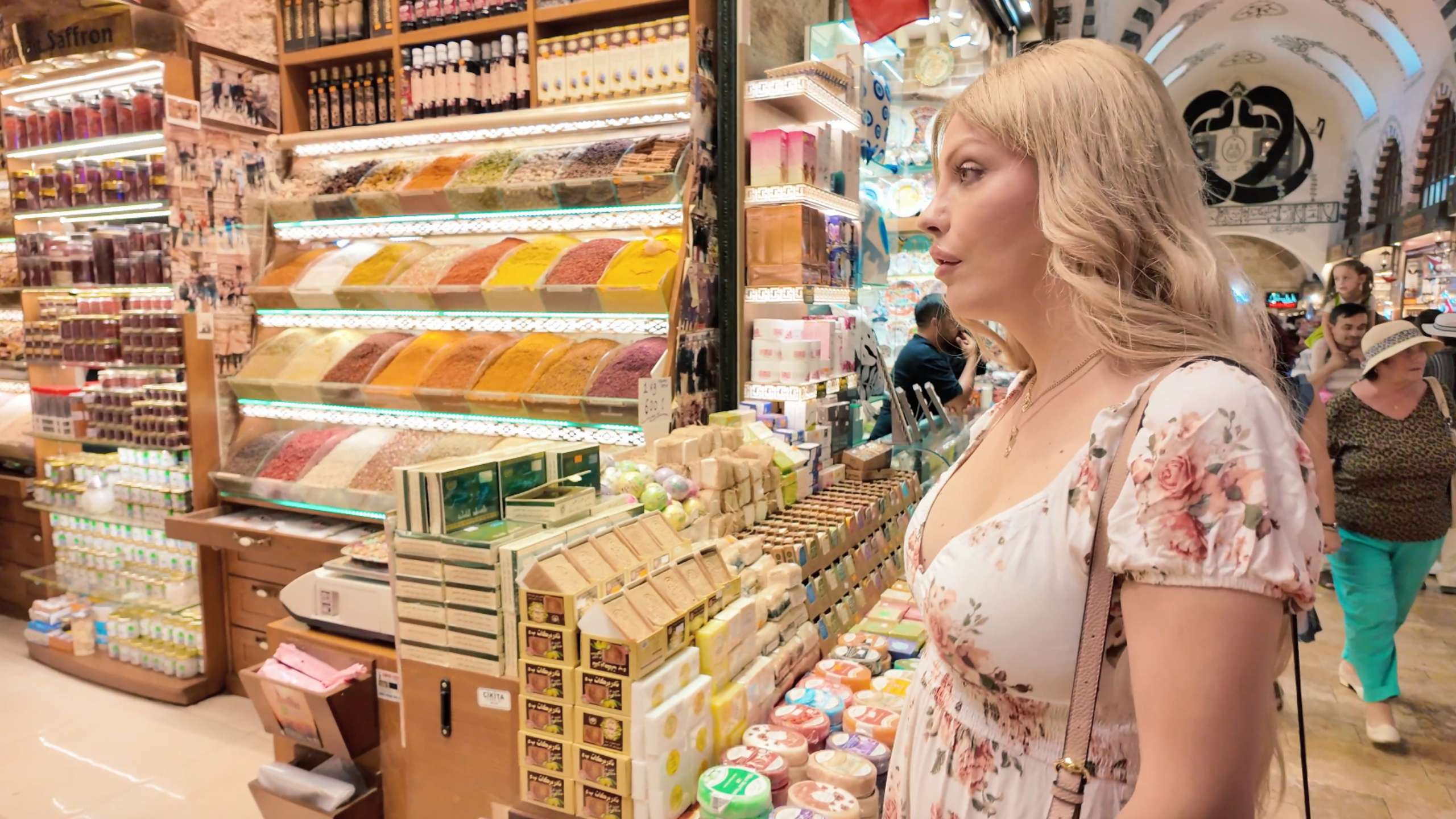 A shopper admires a spice shop filled with unique scents and colors.