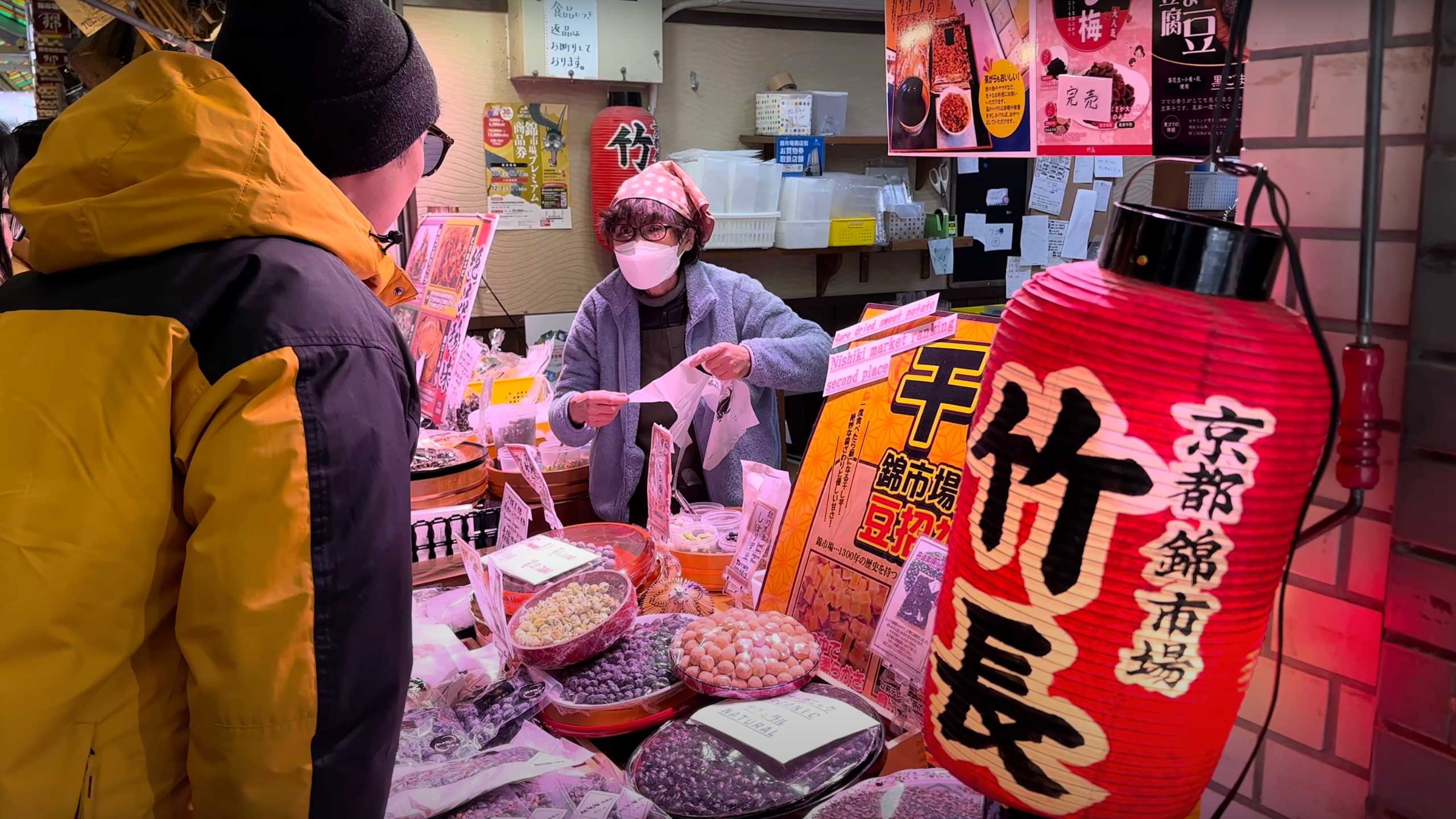 Vendor at Nishiki Market serving customers traditional Japanese treats.