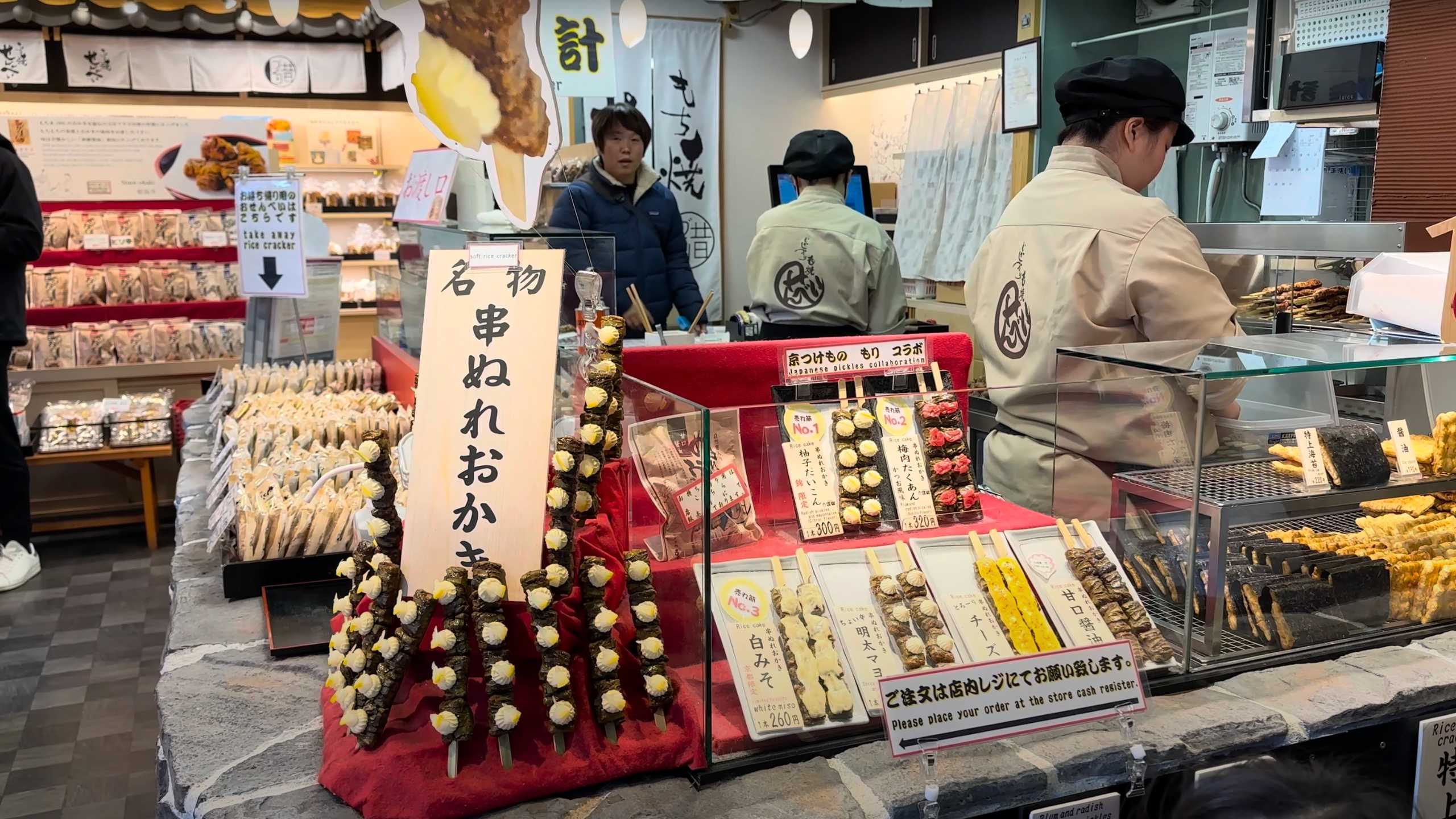 Colorful rice cracker and pickled skewer display in a Japanese shop.