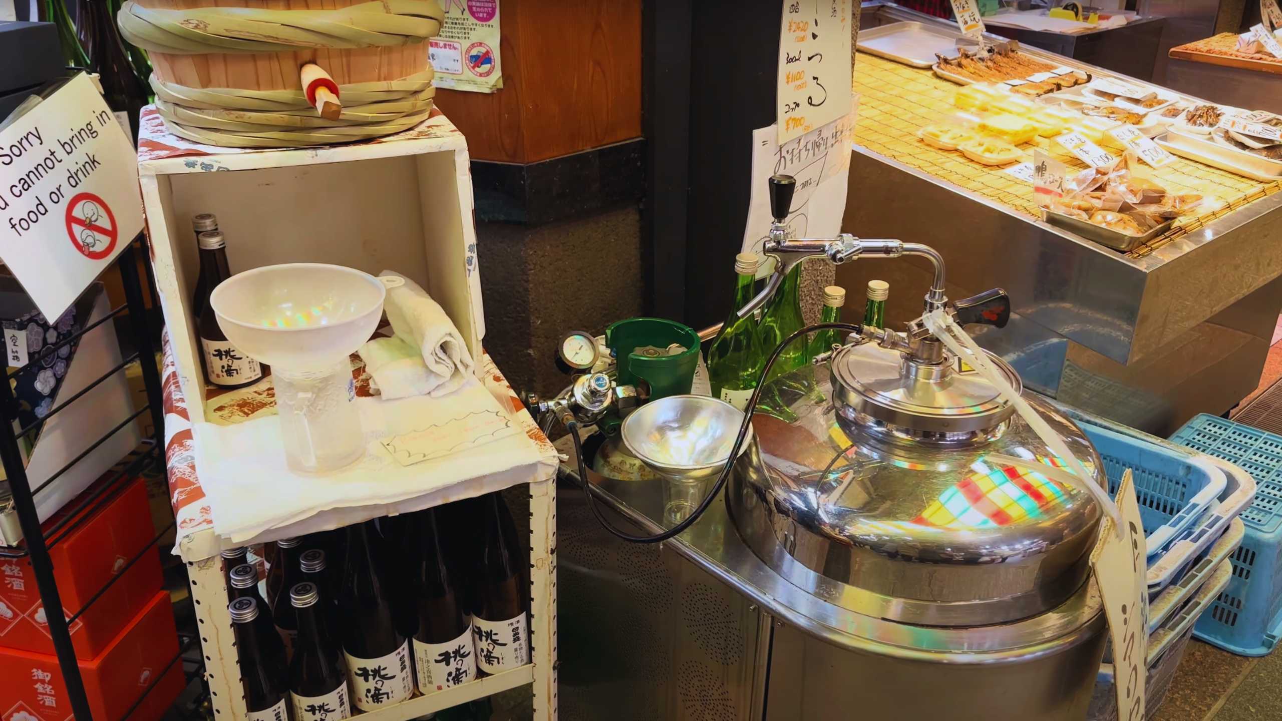 Sake dispenser setup with a no outside food or drink sign.