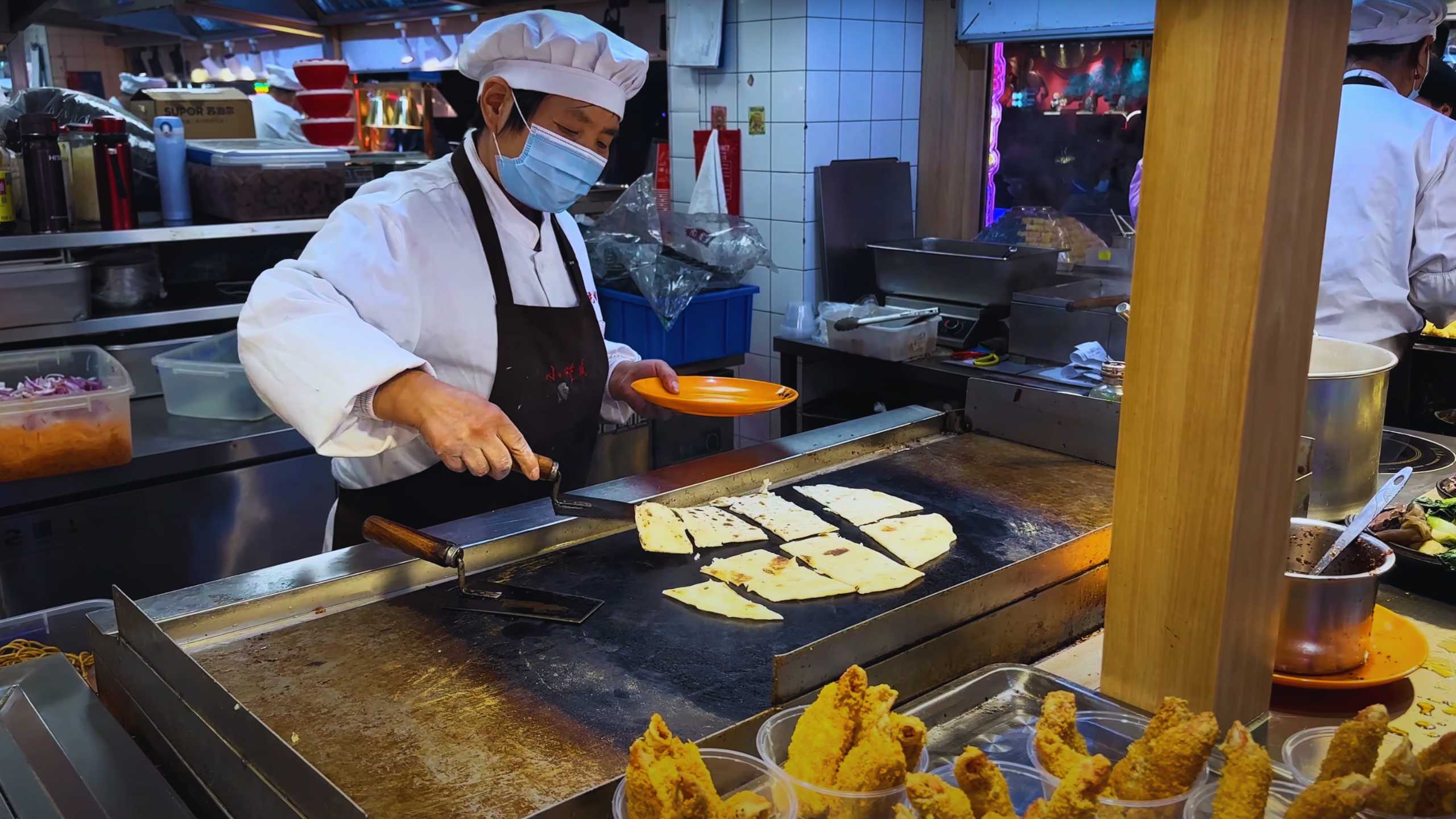 A chef grills flatbreads, preparing them fresh for eager customers.