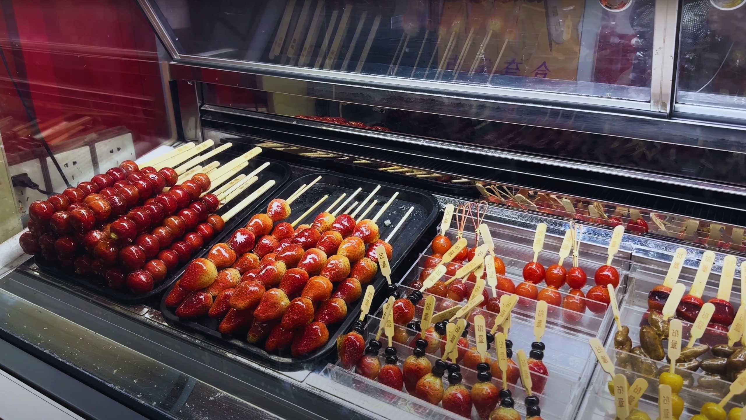 Glazed fruit skewers attract sweet tooths at this vibrant stall.