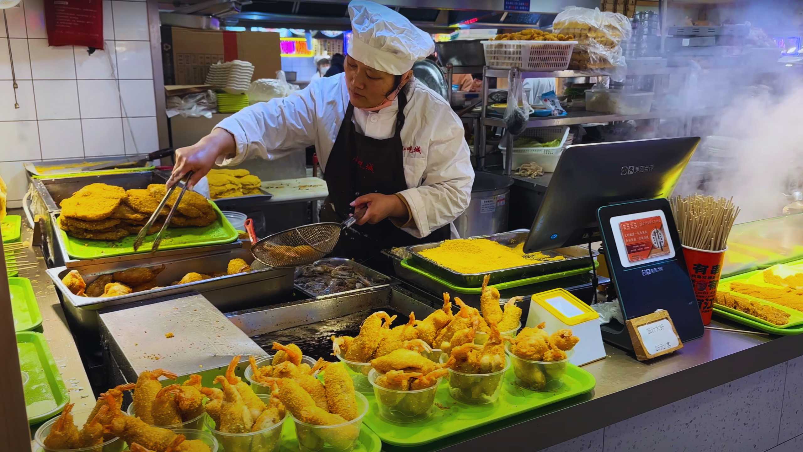 A cook prepares freshly fried seafood in front of a hungry crowd at Yuyuan Bazaar.