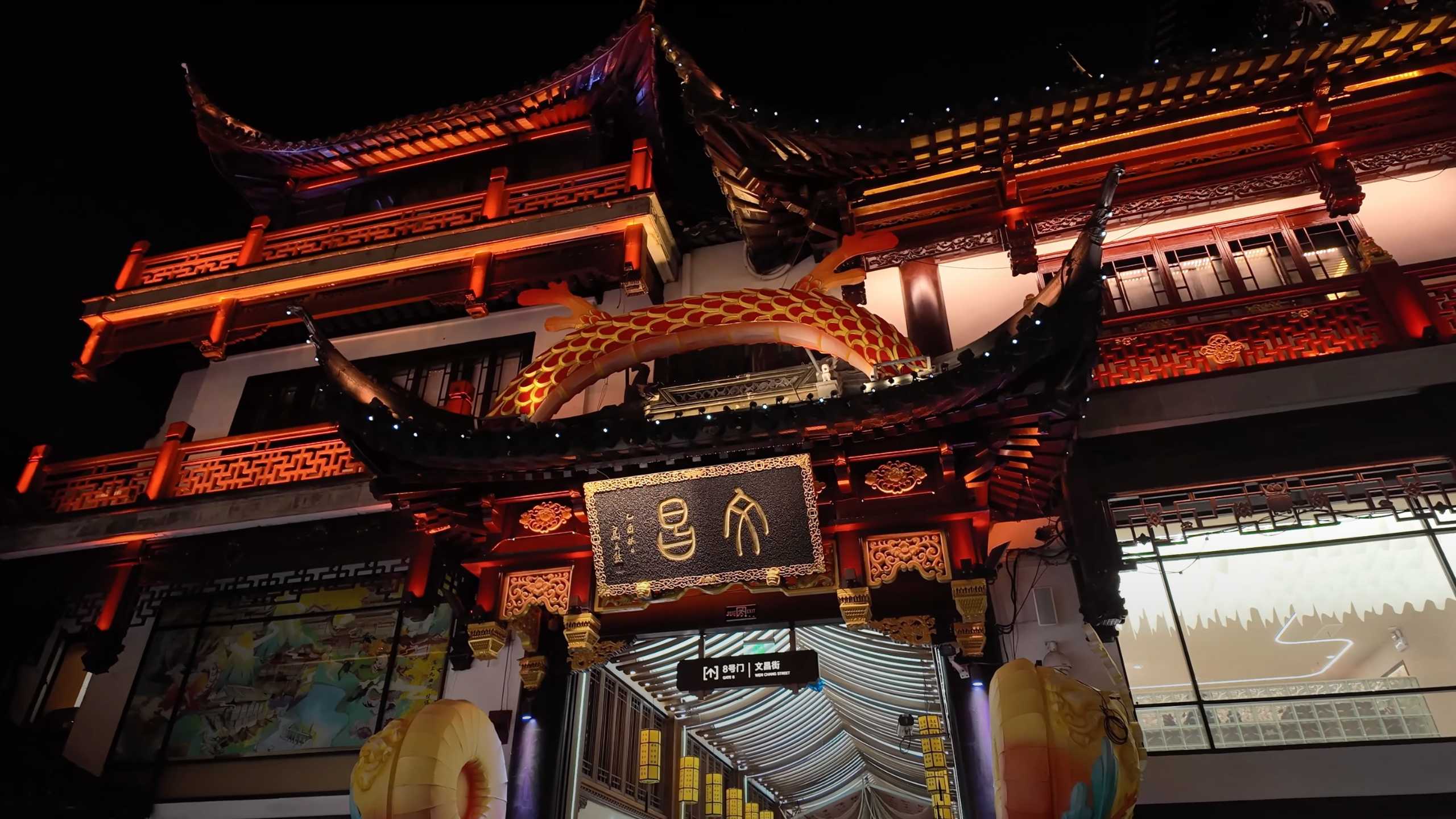 Traditional Chinese archway illuminated at night, welcoming visitors.