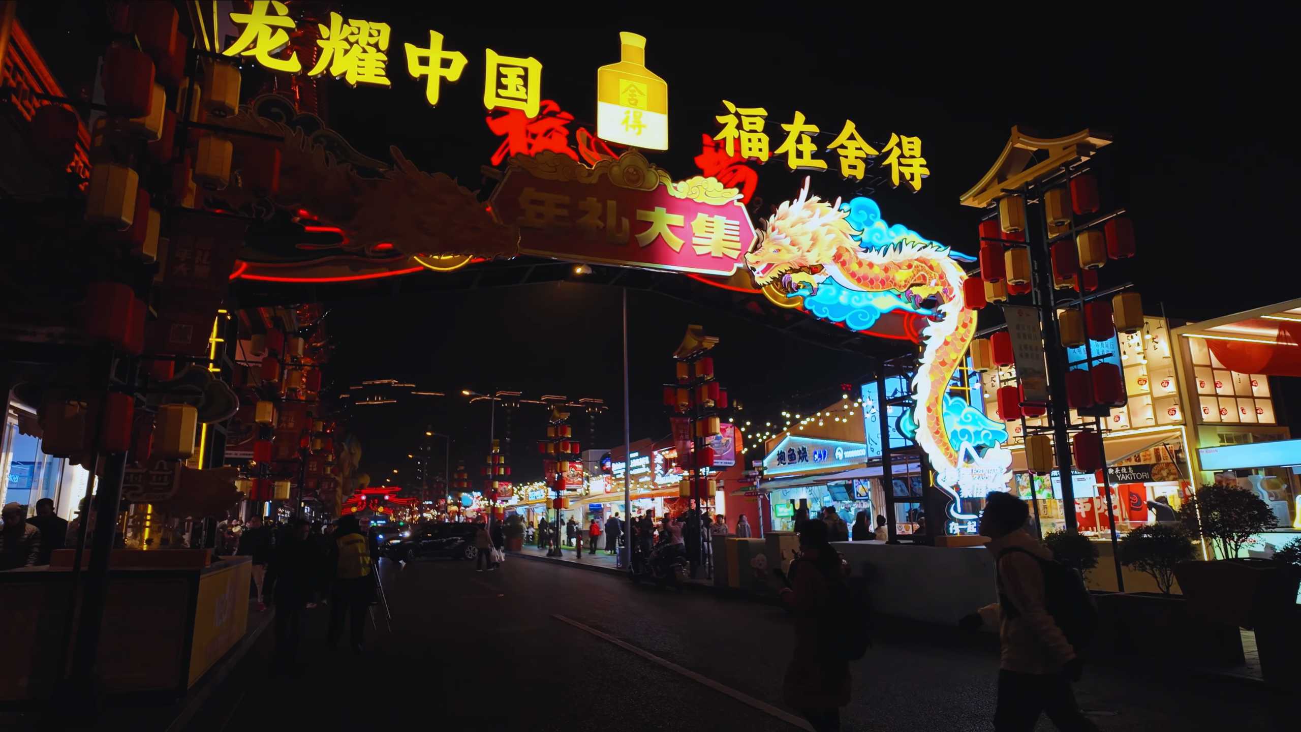 Neon-lit gateway inviting visitors under colorful dragon signage.