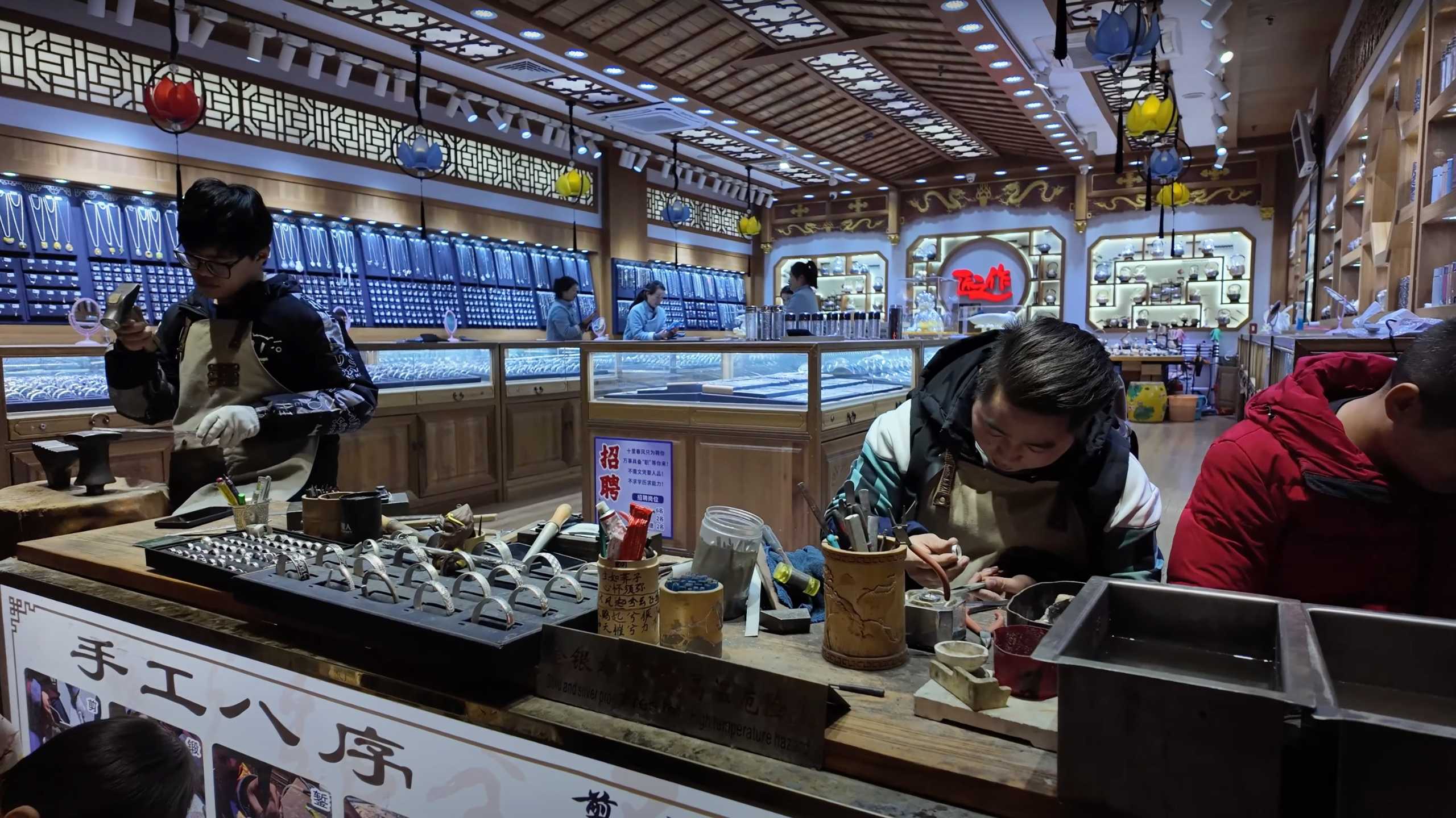 Artisans crafting intricate jewelry pieces in a traditional workshop.