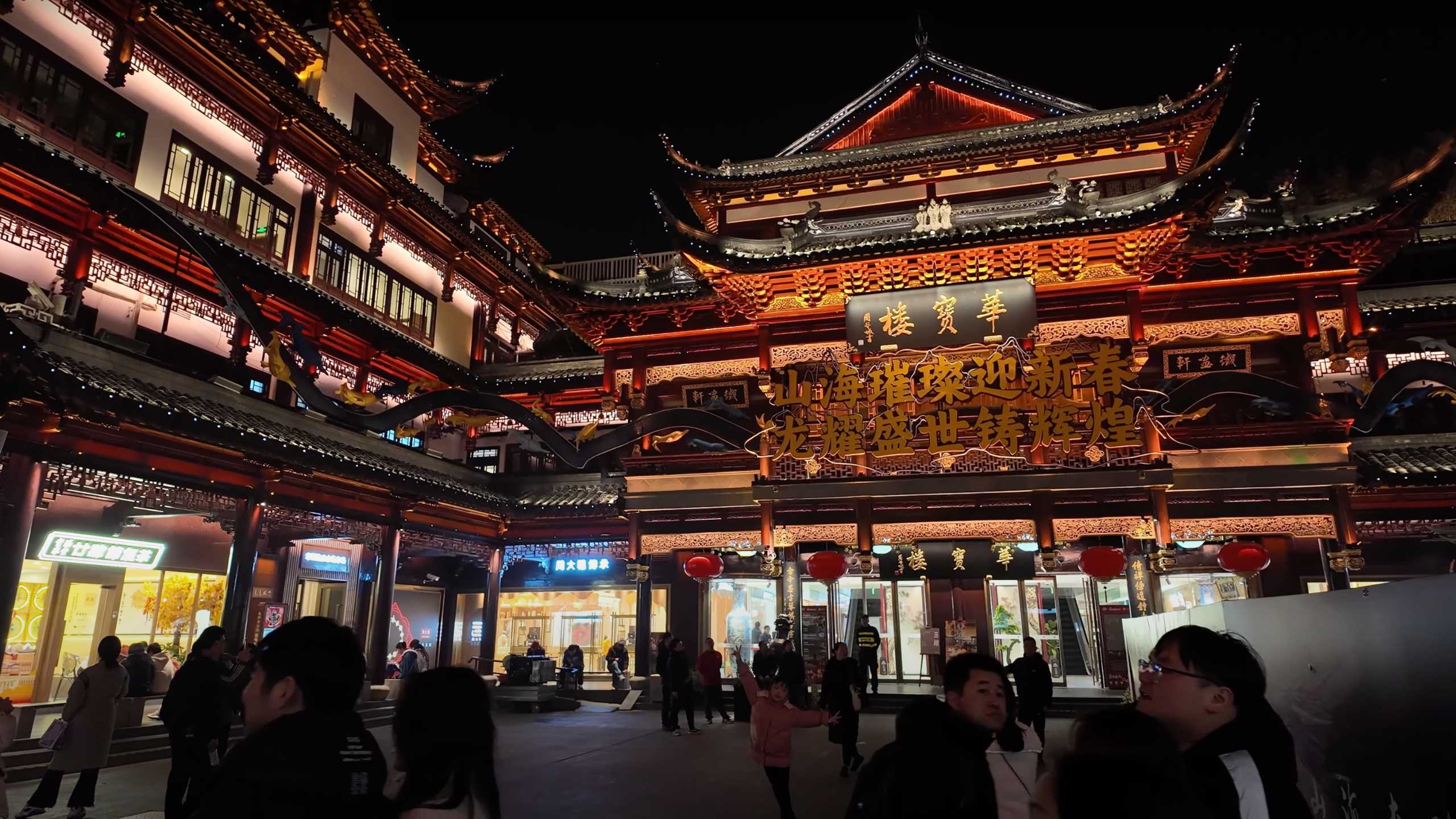 The main square lit up, revealing intricate details of ancient buildings.