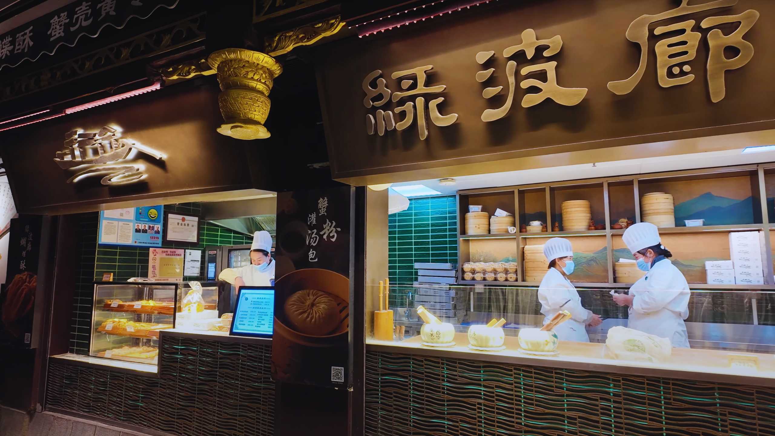 Chefs preparing traditional buns in an open kitchen with authentic decor.