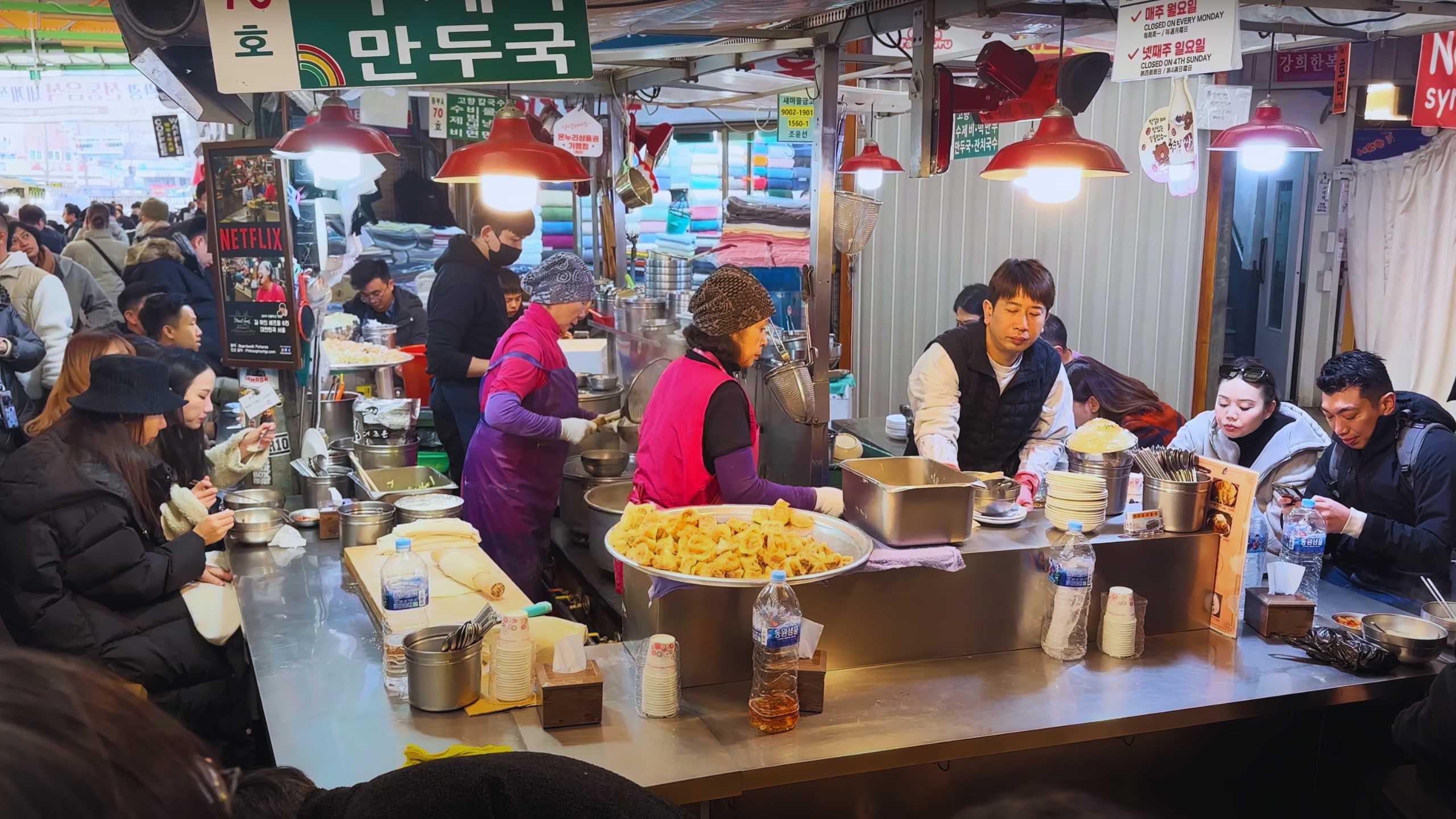 Vendors busily prepare meals, surrounded by colorful signage and vibrant food displays.