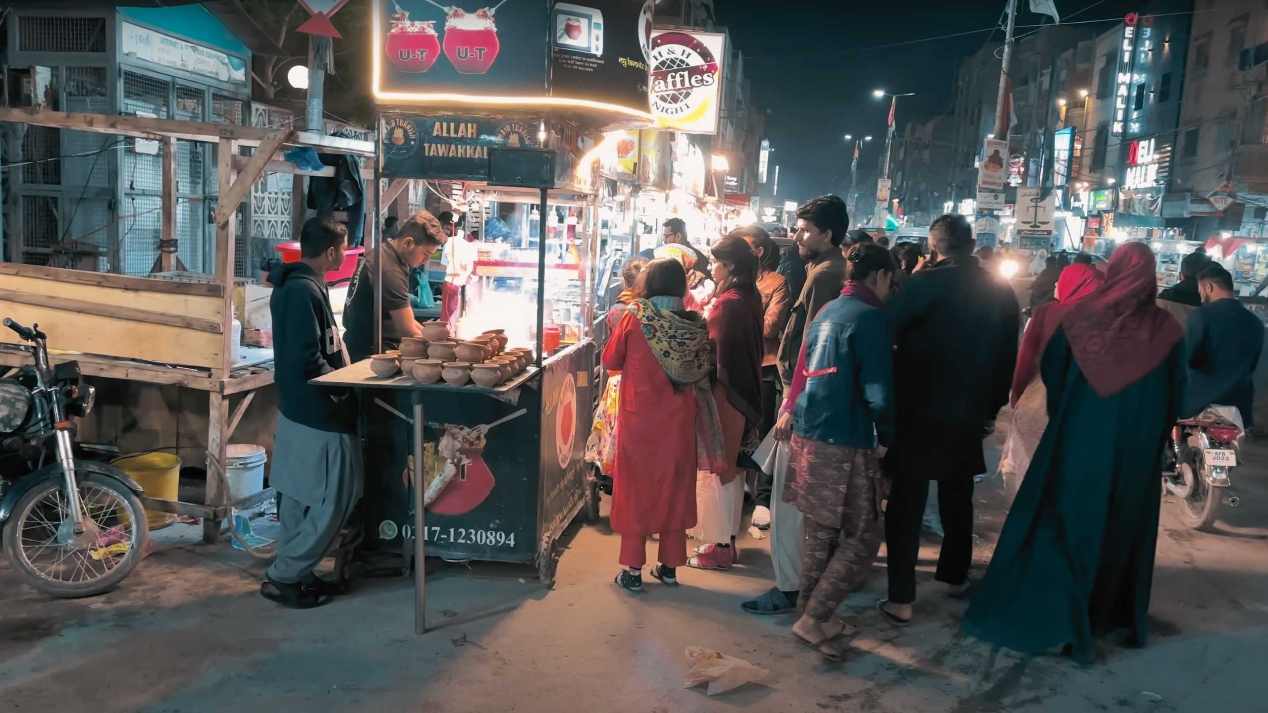 A crowd gathers around a food stall, eagerly waiting for their turn to be served.