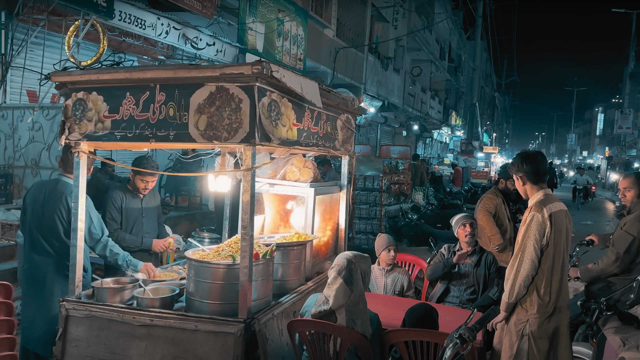 A family enjoying a late-night meal at a cozy food stall.