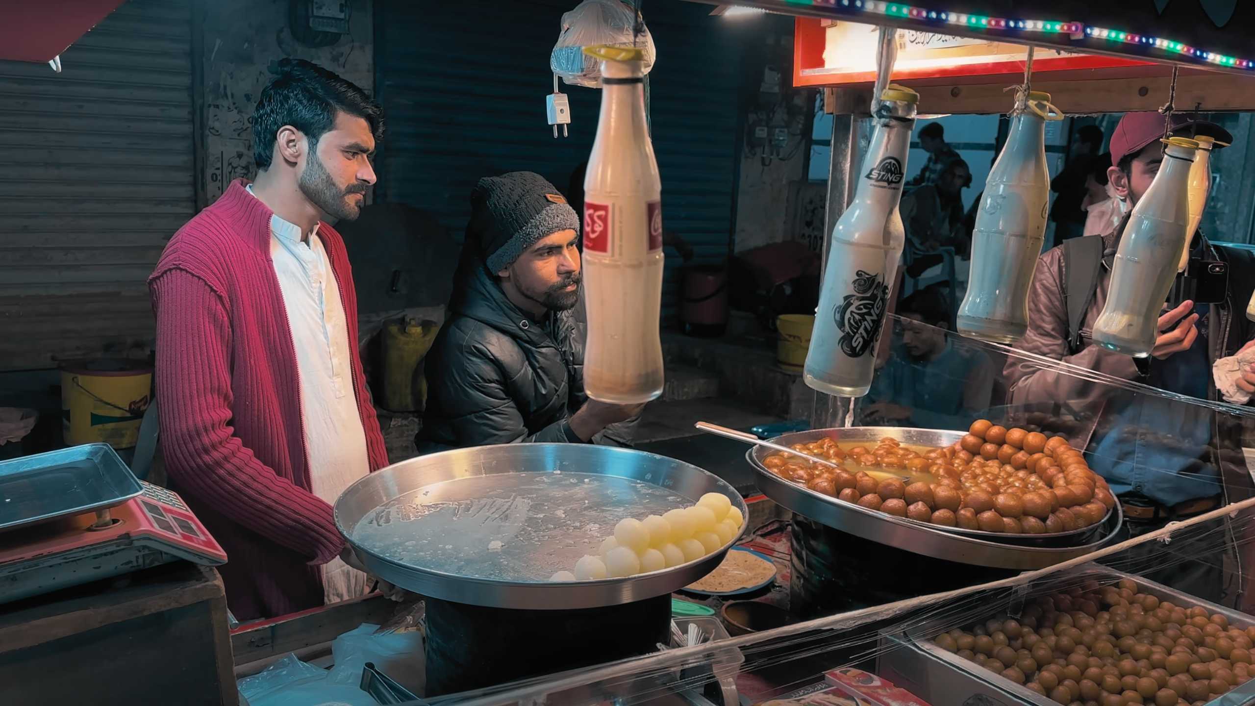 Two men preparing traditional desserts with great focus.