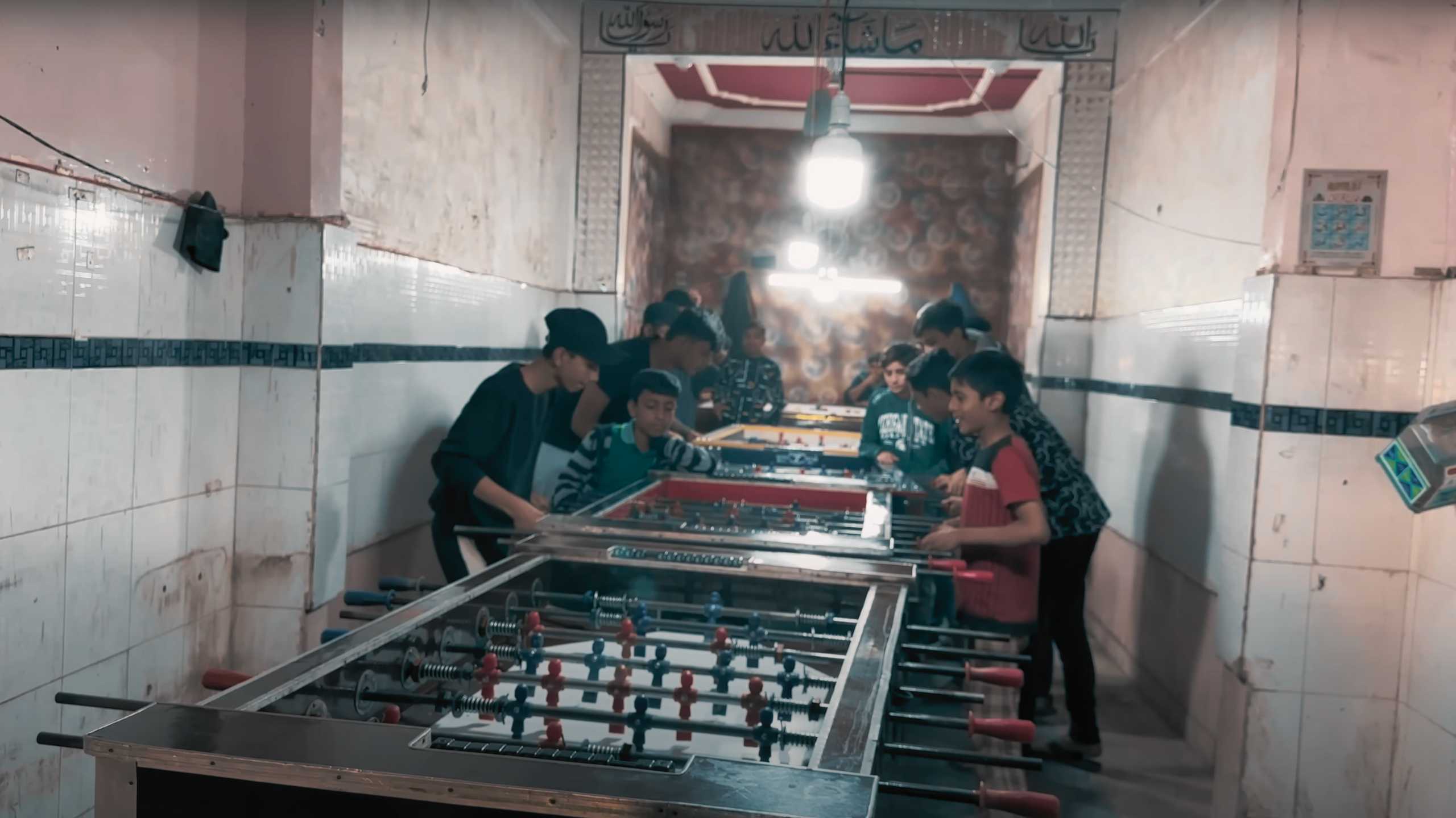 Young boys engrossed in an intense foosball match inside a local game room.