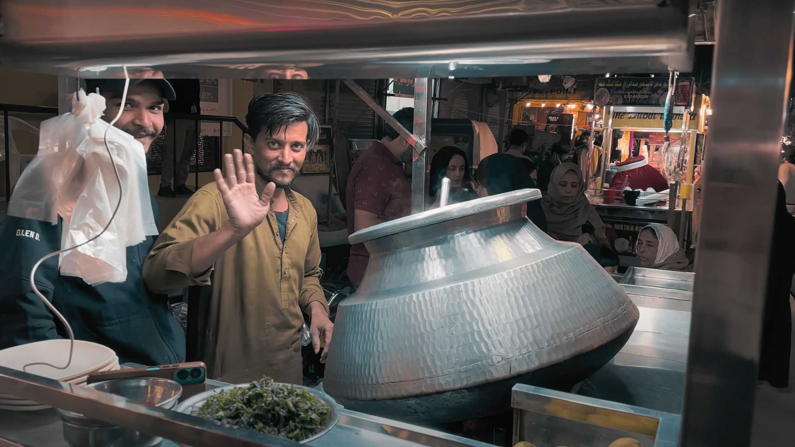 A friendly wave from a vendor, inviting you to try his freshly made biryani.