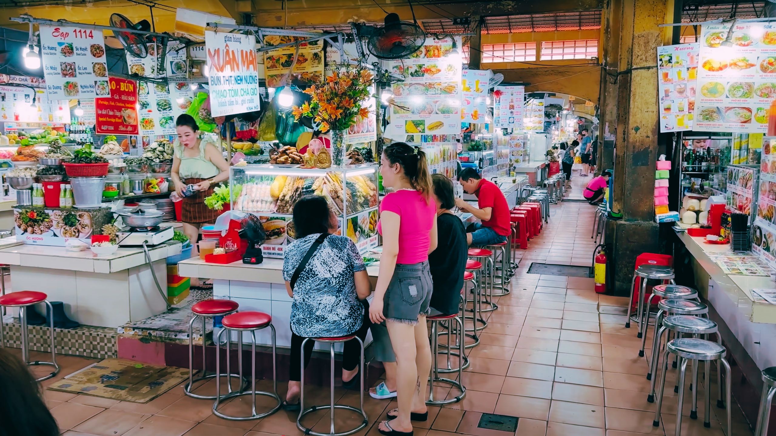 Locals and tourists enjoy street food inside Ben Thanh Market’s busy food court.