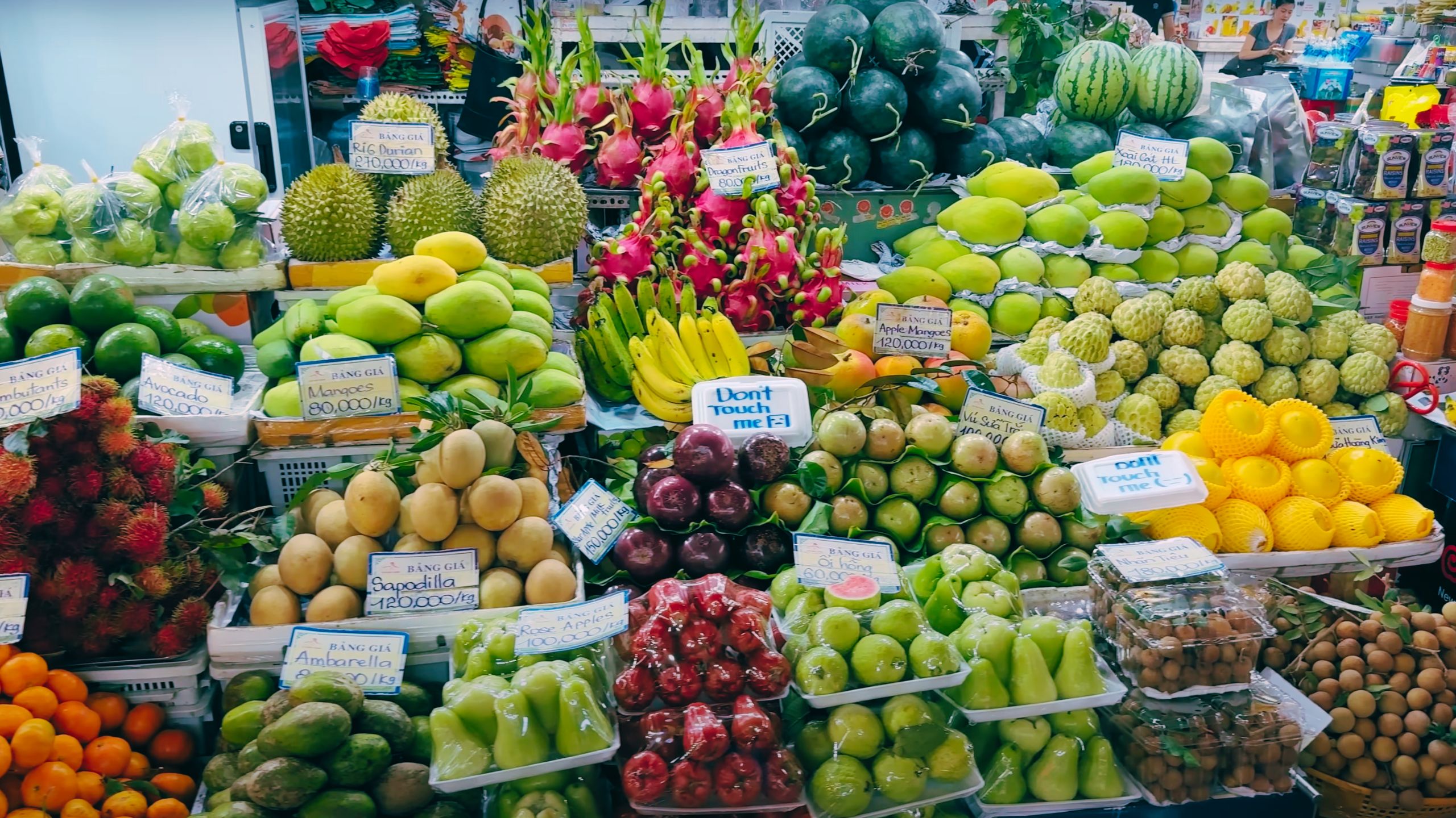 A vibrant fruit stand selling durians, mangos, dragon fruit and other tropical delights.