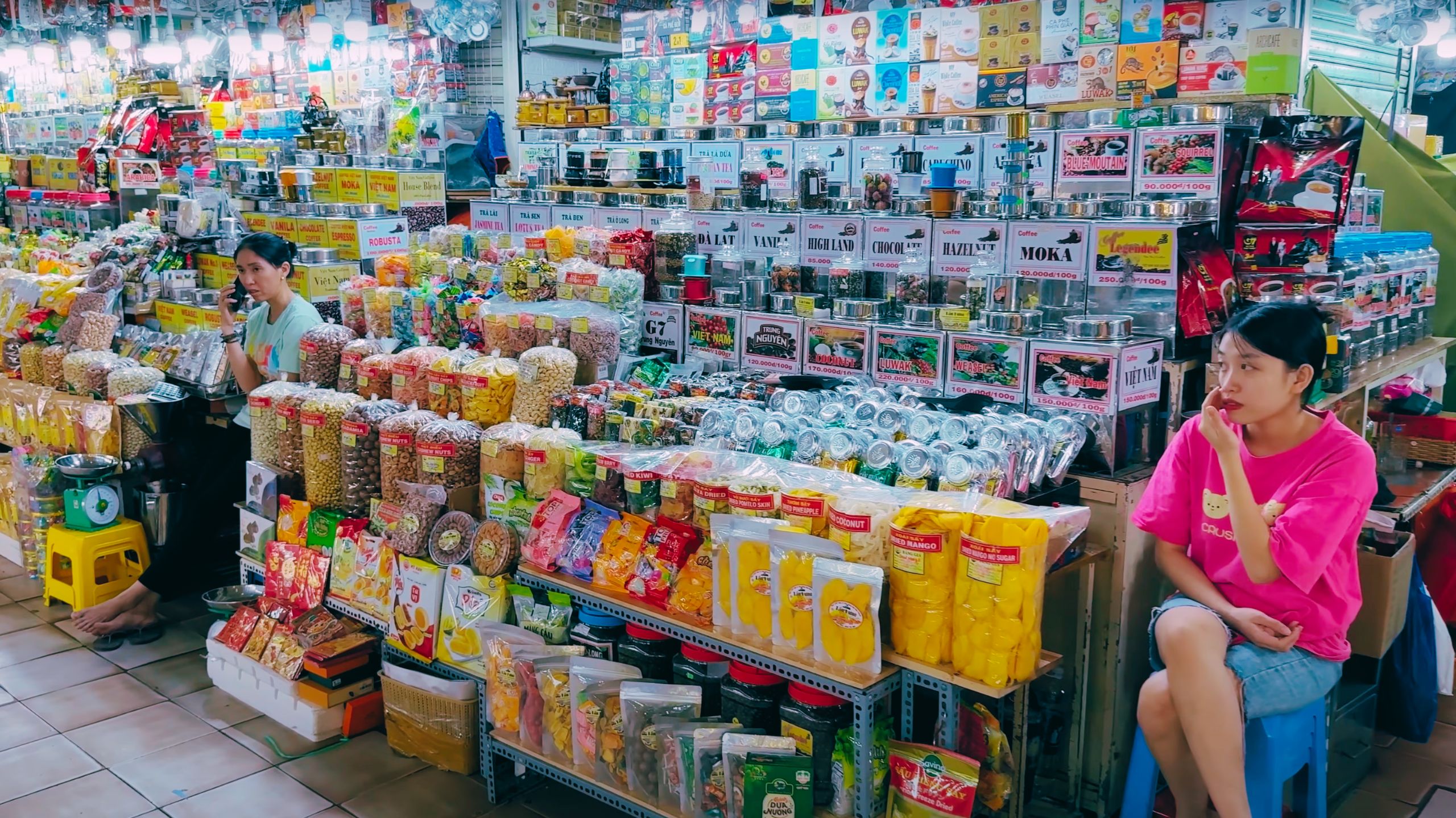 Vietnamese snacks, nuts and dried goods packed in colorful bags at a busy stall.