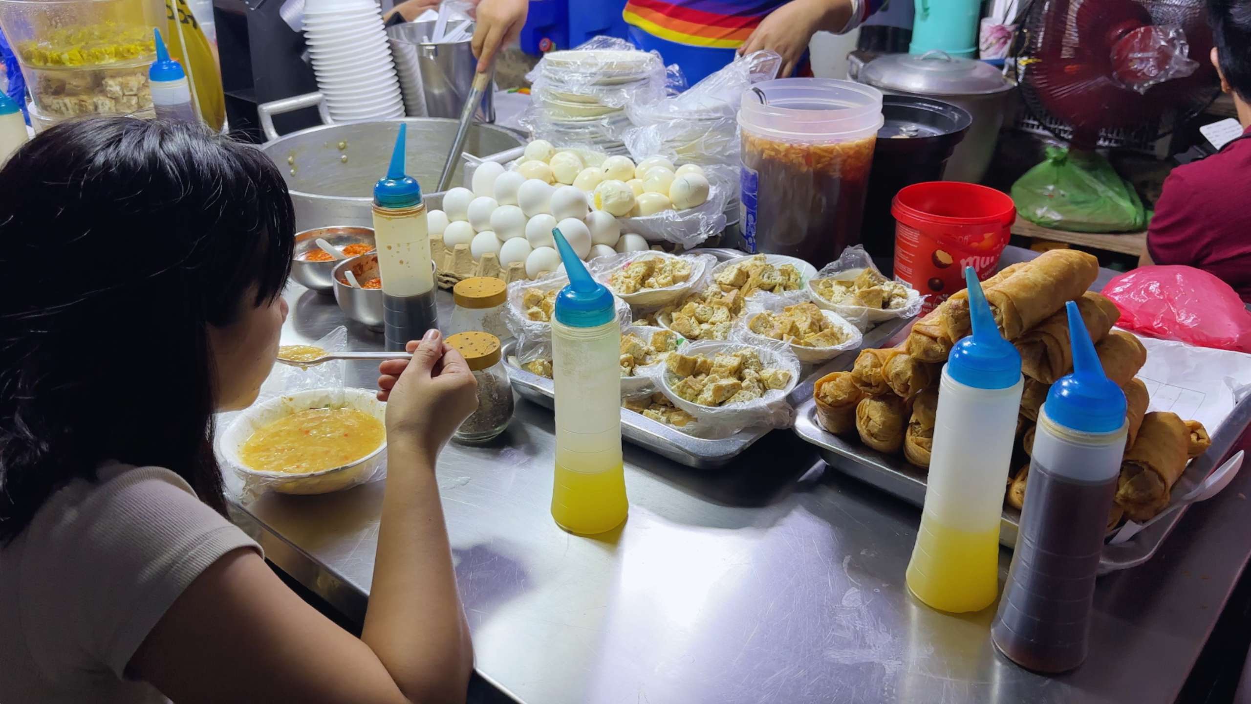 A table of fresh eggs and fried treats being served to a young diner.