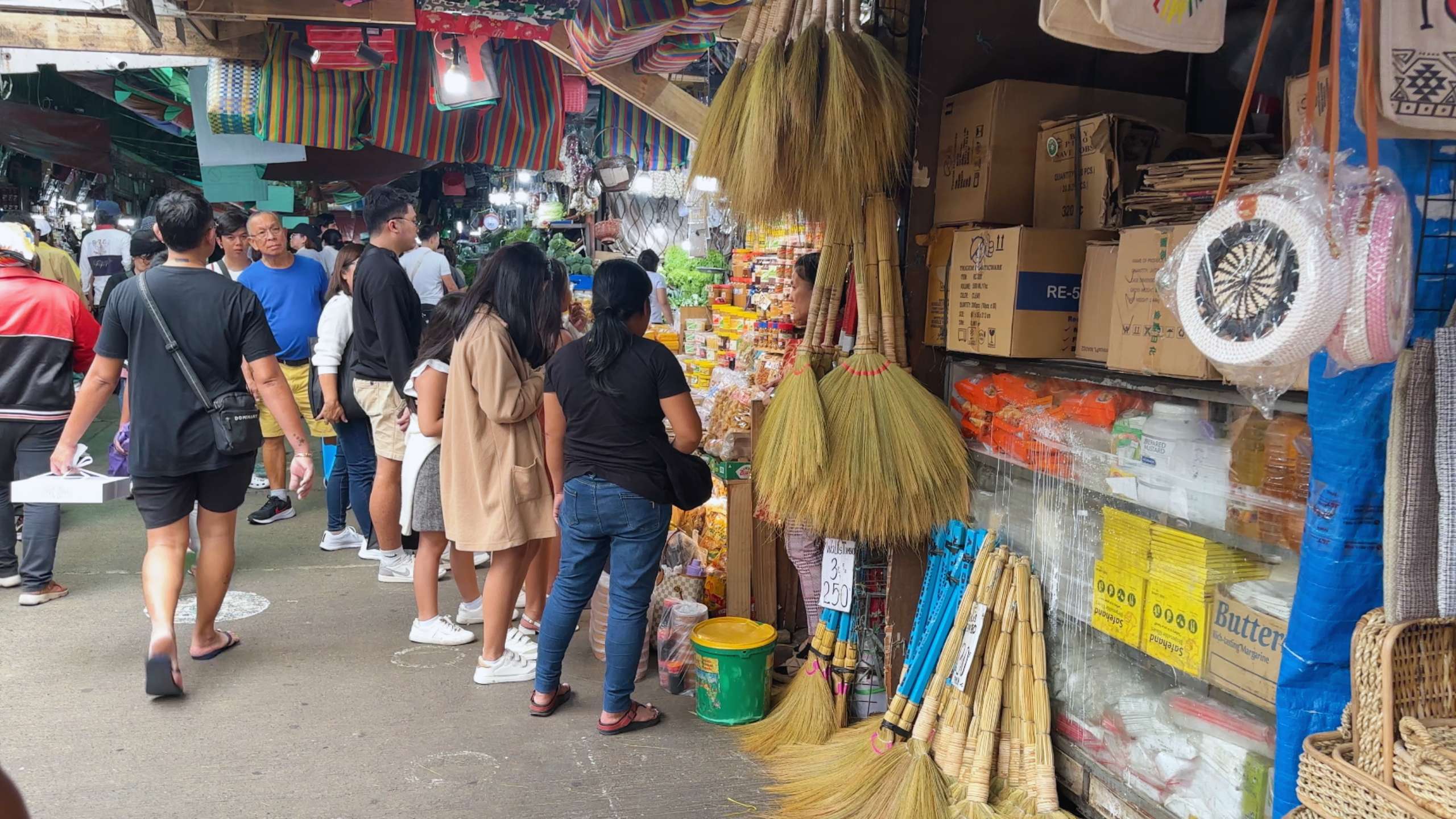 Visitors look at traditional items, including brooms, at a local handicraft stall.