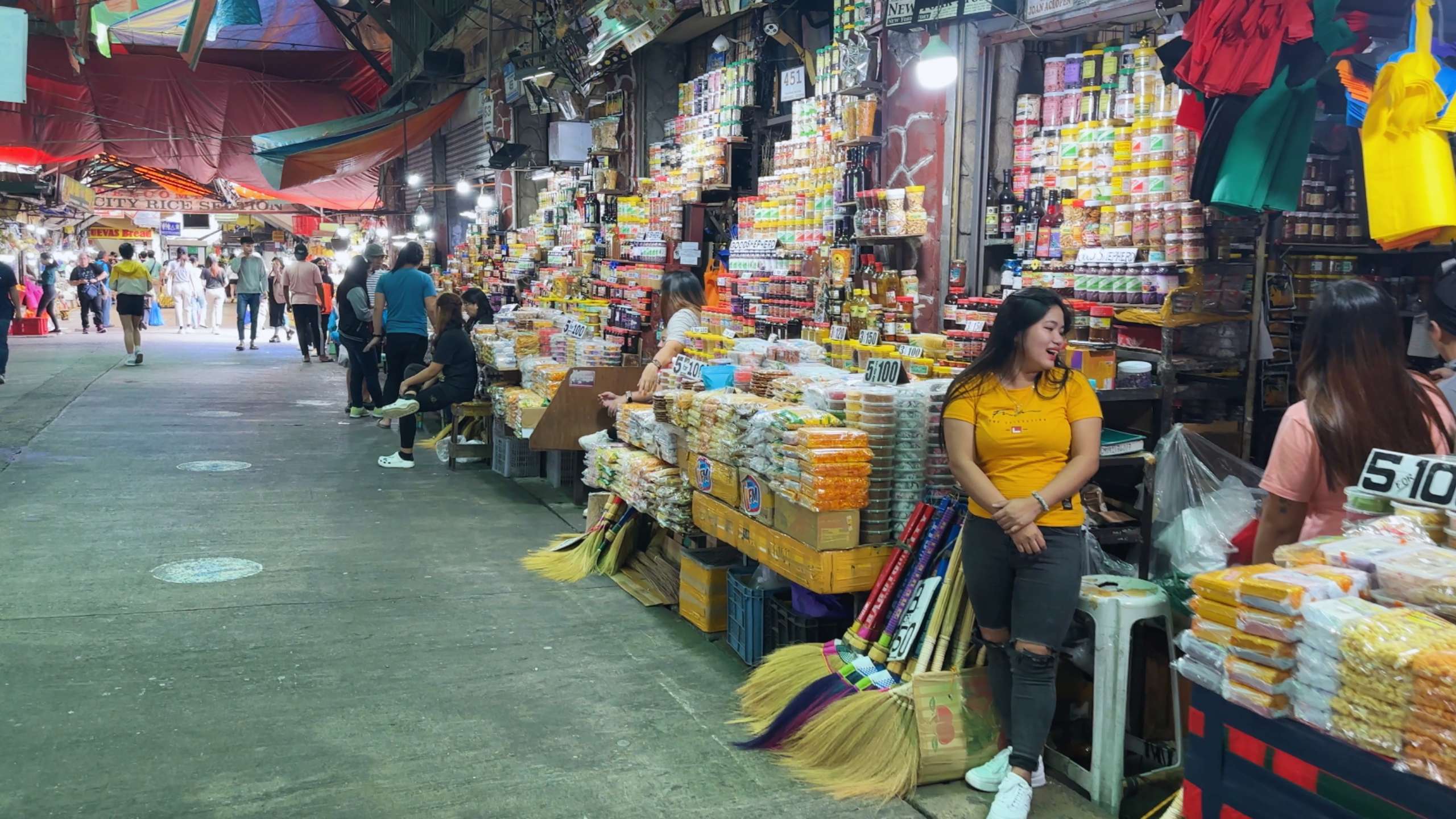 Long rows of goods line the market’s aisles, with shoppers exploring items.