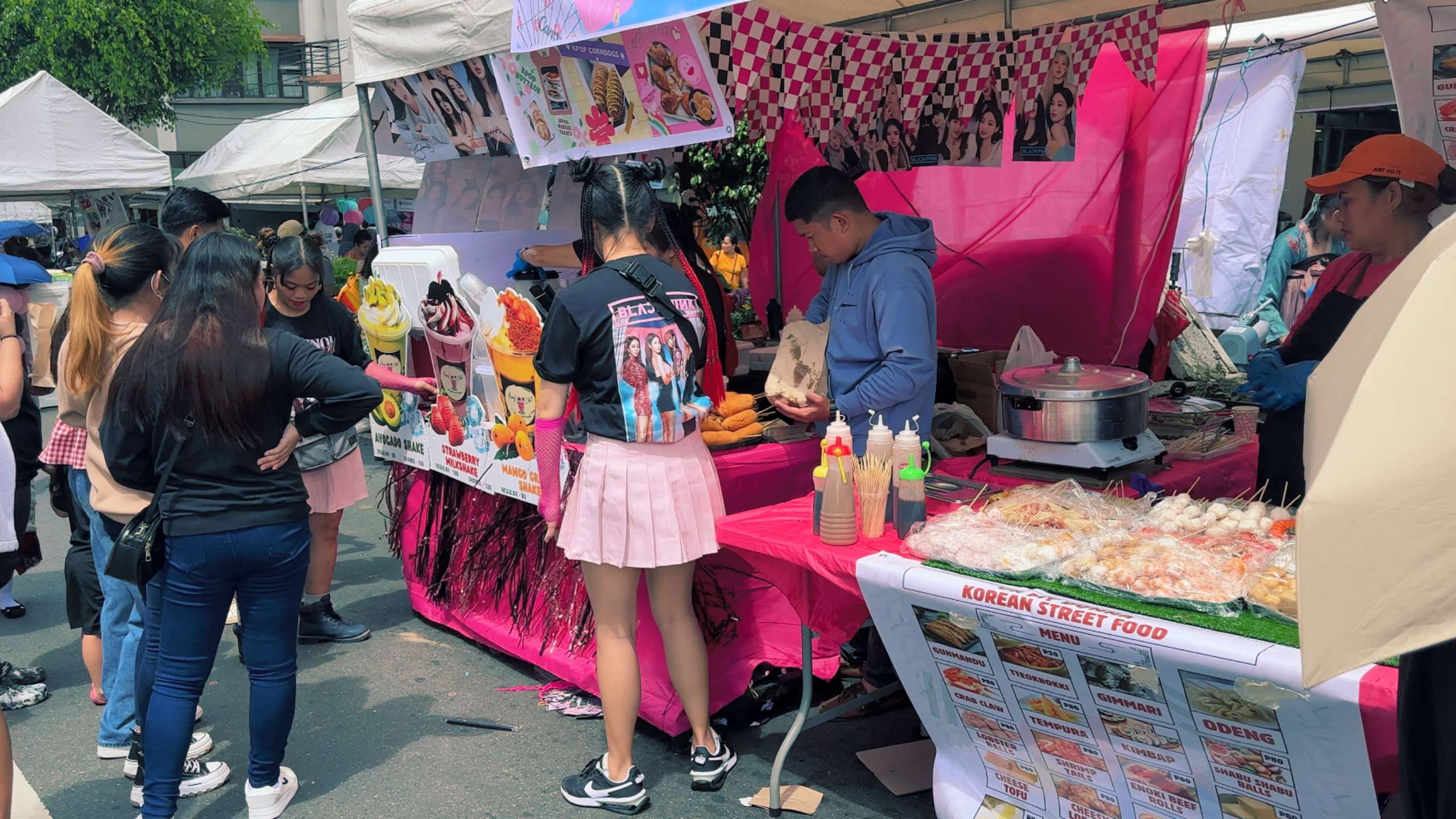 Korean-themed food stall draws customers with colorful signage and unique treats.